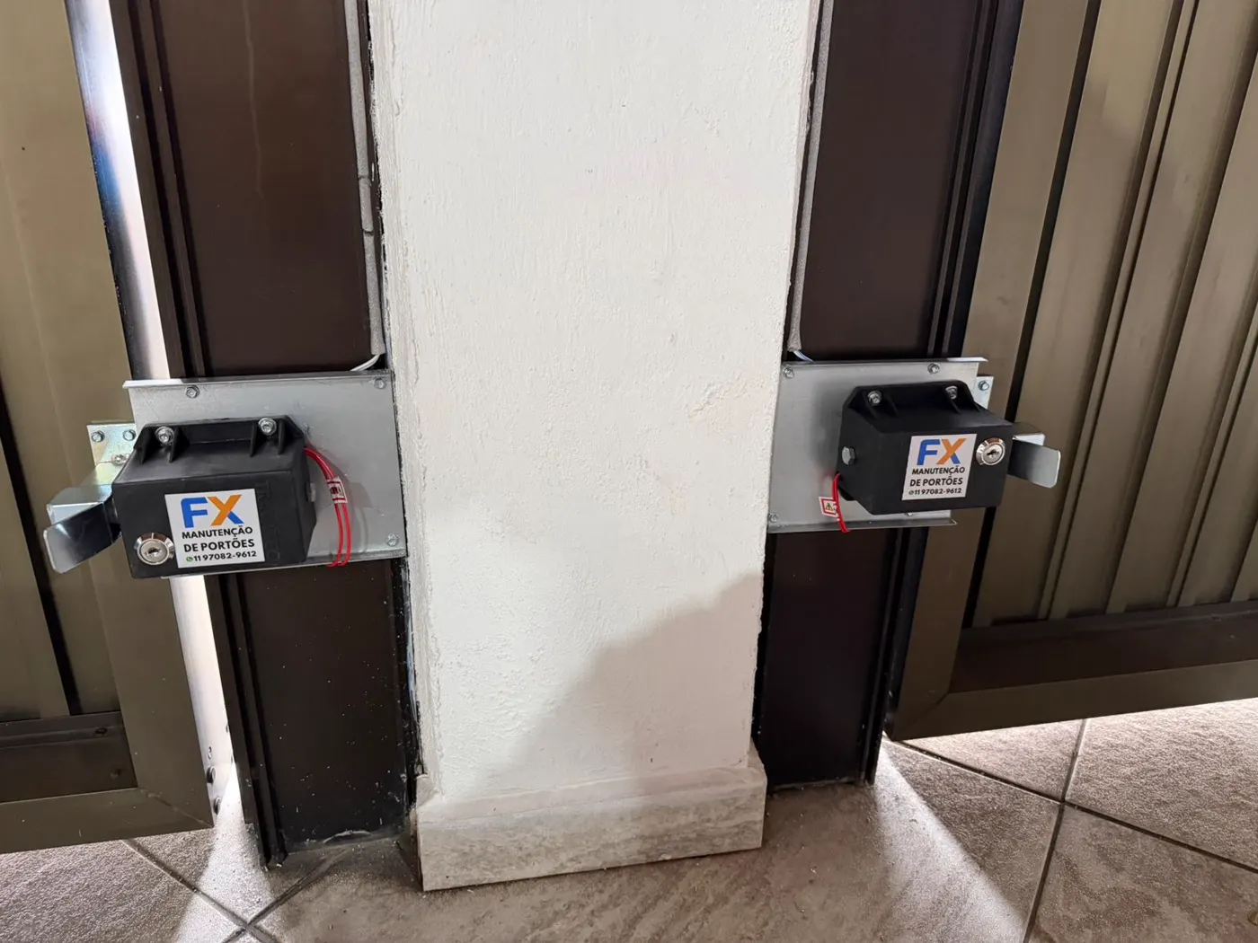 Dois motores de portão automático instalados em portão de duas folhas